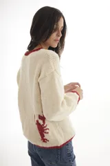 Sweater tejido a mano en Uruguay, de lana merino color crudo con cuello y dibujo de langosta en rojo.