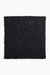 Pañuelo cuadrado negro de algodón con textura y flecos en los bordes.