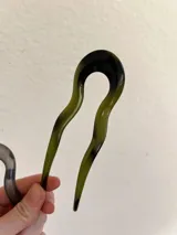 Pinza para el pelo tipo peineta con forma irregular color verde oliva y negro.