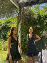 Vestido corto de lentejuelas color verde oliva, con escote en V, breteles finos cruzados en la espalda, cut-outs laterales y volado en el ruedo.