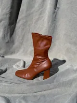 Bota de caña media color marrón, con punta cuadrada y taco geométrico.