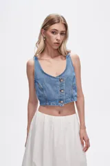Chaleco crop top de jean celeste con botones frontales.