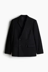 Blazer negro de doble botonadura en tejido suave, con solapas de pico, bolsillo superior, bolsillos ribeteados con solapa adelante y dos bolsillos en el interior. Botones decorativos en los puños y doble abertura atrás. Corte estándar y forro interior.