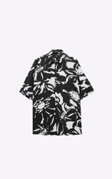 Camisa de manga corta con estampado floral abstracto en blanco y negro, calce oversize y canesú en la espalda.