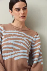 Sweater marrón con estampado animal en celeste, tejido en jacquard de algodón con acrílico, de textura cálida y liviana. Tiene mangas abullonadas y puños elastizados.