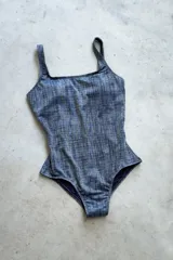 Traje de baño enterizo color dorado con textura brillante, escote recto, tiras anchas y espalda cuadrada.