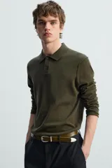 Polo manga larga color marrón, de punto tejido en hilatura italiana, corte regular fit, cuello solapa con cierre frontal de botonadura y acabados en rib.