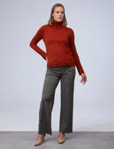 Polera de punto fino marca Nienty, color blanco, con cuello alto volcado y mangas largas con detalle de tajo en los puños.