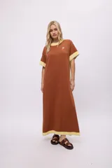 Vestido largo de algodón, color rojo, con cuello redondo y ribetes en color crema en cuello, puños y ruedo. Presenta un pequeño bordado en el pecho.