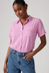 Camisa de manga corta con estampado a cuadros rosa y blanco, cuello clásico y cierre frontal con botones.