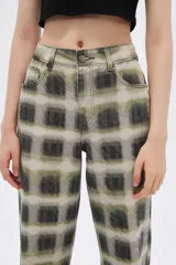 Pantalón de jean con estampado tie dye en tonos verde oliva y gris, de corte holgado y tiro alto.