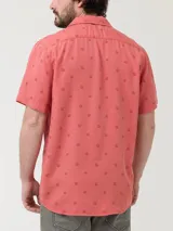 Camisa celeste con estampado de peces negros, de manga corta y corte recto.