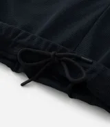 Pantalón deportivo negro de tela texturizada, con cintura elástica y bolsillos con cierre.