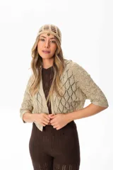 Saco corto color beige tejido a crochet con hilo con lurex y spandex, mangas murciélago y calce amplio.