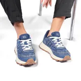 Zapatillas urbanas azules de tela denim con cordones blancos, suela de goma color crema y detalle de etiqueta con letras XL en la lengüeta.