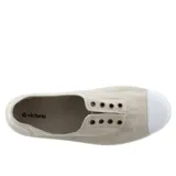 Zapatillas de lona color beige sin cordones, con puntera de goma blanca y suela de caucho vulcanizado.