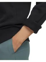 Buzo Under Armour para mujer, modelo Rival Fleece Shimmer, color negro con logo frontal estampado en azul brillante. Cuenta con capucha con cordón ajustable y bolsillo tipo canguro.