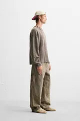 Sweater marrón de cuello redondo y manga larga, tejido con textura bouclé y efecto lavado.