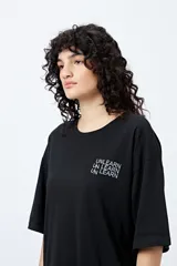 Remera blanca de corte amplio con mangas cortas y estampado con la frase "Unlearn" en el frente y gráfico en la espalda.