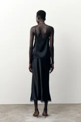 Falda midi negra de satén con cintura elástica y detalle de encaje en el ruedo.