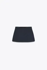 Falda pantalón corta color azul marino a rayas verticales, de tiro medio con cinturón negro de hebilla metálica. Cuenta con bolsillos laterales y cierre frontal con cremallera y gancho metálico.