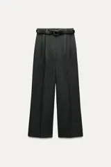 Pantalón gris oscuro de tiro alto con pinzas delanteras, pernera ancha y cinturón de cuero negro con hebilla redonda.