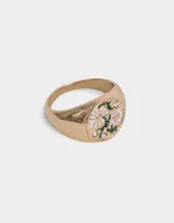 Anillo dorado con diseño de flores esmaltadas en blanco y rosa, con detalles de strass.