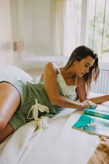 Pijama de short y musculosa color celeste con textura acanalada. La musculosa tiene escote en V con detalle de puntilla blanca y tirantes finos blancos. El short tiene elástico y lazo blanco en la cintura.