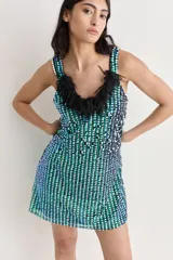 Vestido corto de fiesta, cubierto de lentejuelas plateadas, con escote en V y flecos de tul color crema.