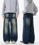 Jean de mezclilla azul oscuro con lavado desgastado y paneles con costuras diagonales pronunciadas, de corte ancho y holgado.