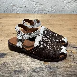 Sandalias bajas de cuero marrón con tiras de cuero trenzado y detalles de cuero con estampado animal en blanco y marrón.