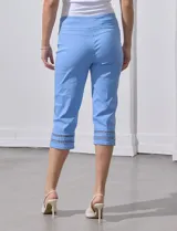 Pantalón capri blanco de gabardina elastizada con bolsillos simulados, pretina ancha, corte recto y detalle de puntilla en el ruedo.