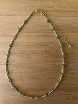 Gargantilla corta con cuentas doradas y cuentas de piedra color aguamarina.