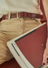 Cinturón marrón de cuero con hebilla metálica dorada y perforaciones circulares.