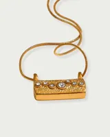 Collar dorado con cadena de eslabones y dije rectangular con textura y cristales incrustados.