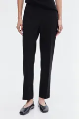 Pantalón cigarette negro de punto elástico pesado con pliegues. Modelo de tiro alto con elástico oculto en la cintura y pinzas adelante y atrás.