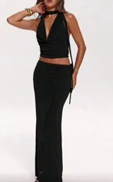 Set de dos piezas negro, compuesto por un top halter con cuello tipo choker y escote drapeado, y una falda larga ajustada al cuerpo.