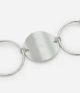 Cinturón de metal plateado con argollas y rodelas.
