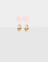 Set de dos pares de aros: un par de aros pasantes con forma de corazón color rosa y un par de aros argolla dorados.