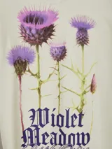 Camiseta color crema con estampado de flores y texto en la espalda.