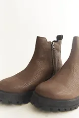 Botas cortas marrones con textura símil cuero de reptil, elástico lateral, cierre lateral con cremallera y suela track.