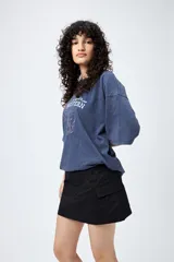 Minifalda negra estilo cargo, de corte recto y tiro bajo, con bolsillos laterales.