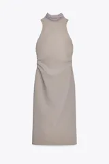 Vestido midi color gris topo, de cuello halter con lazada combinada a tono. Bajo con abertura en espalda. Cierre en espalda con cremallera, abertura y botón.