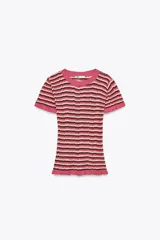 Camiseta de punto con rayas horizontales en tonos rosa, marrón y beige. Tiene cuello redondo con ribete y mangas cortas con volantes en los extremos.