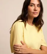 Blusa color amarillo claro, confeccionada en viscolino, con cuello redondo y mangas cortas abullonadas.