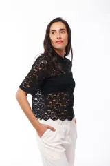 Camisa blanca de encaje con cuello clásico, cierre frontal con botones y mangas cortas.