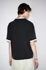 Remera negra de corte holgado confeccionada en tejido de algodón pesado con cuello redondo ribeteado y diseño estampado con la palabra "Venice" en el frente.