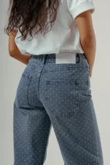 Pantalón de denim tiro alto, corte wide leg, color azul medio con estampado de pequeños lunares blancos.