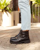 Botas de cuero negras con suela track, cierre frontal dorado y dos hebillas decorativas en el empeine.