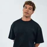 Remera negra de algodón con cuello redondo y mangas cortas. Estampado pequeño en el pecho con texto y logo de la marca KicksLab.